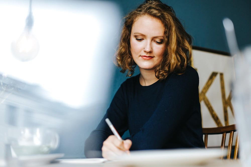 Executive assistant candidate preparing for interview with research notes and laptop